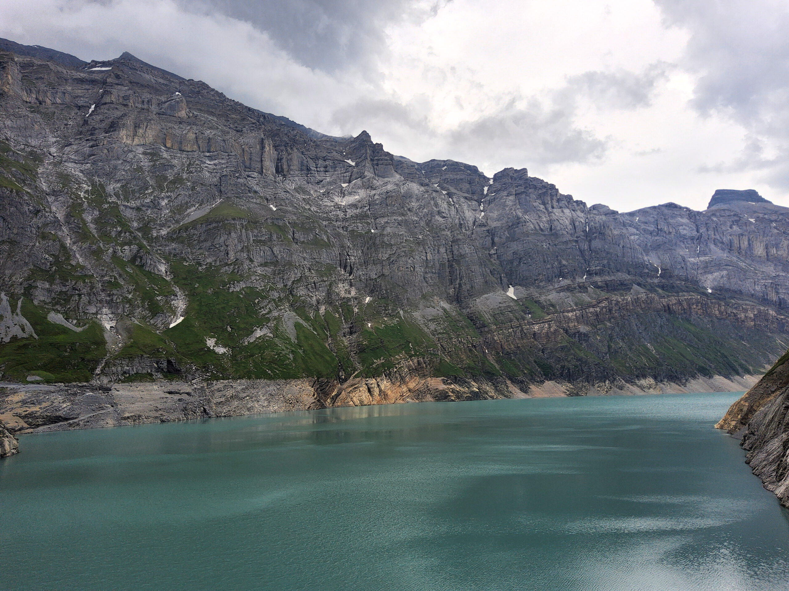 peaceful Swiss lake with hills and small boats in the background
